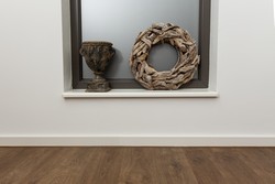 Kranz und Krug nebeneinander auf einer Fensterbank